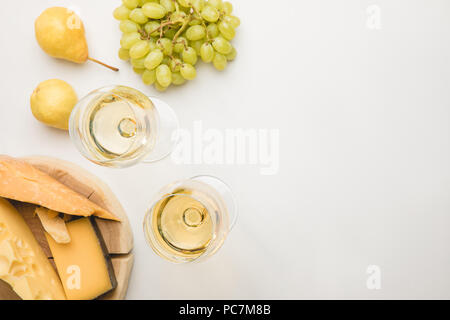 Vue de dessus de différents types de fromages sur planche de bois, de verres à vin et les fruits on white Banque D'Images