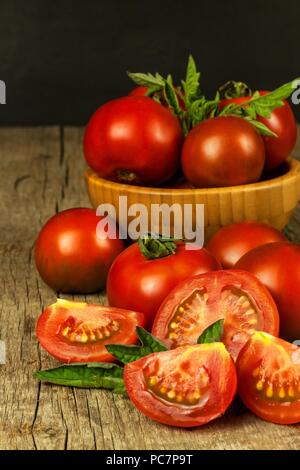 Les tomates fraîches sur une vieille table en bois. Culture des fruits et légumes. Alimentation saine. Matières de la nourriture végétarienne. Vente de tomates Banque D'Images