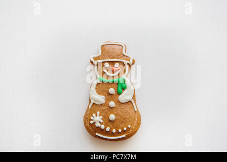 Un Noël traditionnel gingerbread cookie dans la forme d'un bonhomme de neige sur un fond blanc. Banque D'Images