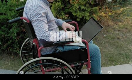 Un homme handicapé en fauteuil roulant président utilise un casque de réalité virtuelle Banque D'Images