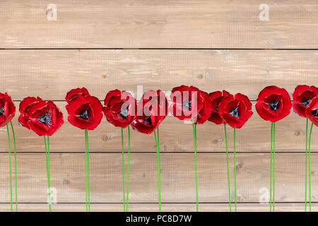 Ligne de métal rouge coquelicots sculpté contre un mur de bois à Tatton Park RHS Flower show 2018, Cheshire, Royaume-Uni Banque D'Images