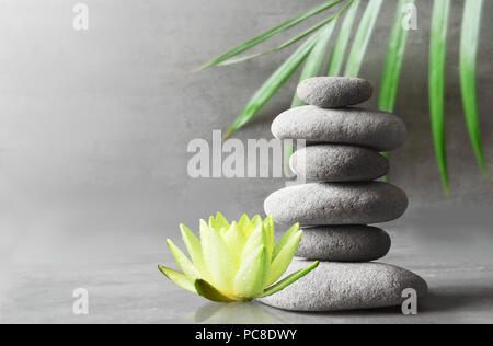 L'équilibre des pierres, blanc fleur lotus et vert feuille de palmier. Concept spa et zen. Banque D'Images