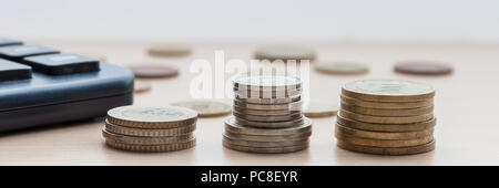 Pièces de monnaie dans les colonnes sur la table en bois Banque D'Images