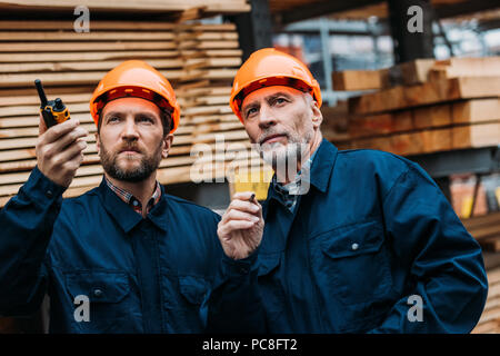 Deux constructeurs de casques bleus qui travaillent à l'extérieur sur la construction Banque D'Images