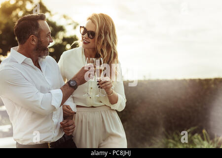 Romantic couple toasting verres à vin à l'extérieur. Belle femme de trinquer le verre de vin avec son petit ami. Banque D'Images