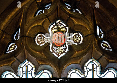 Une rose rouge de verre décoratif fenêtre dans un châssis de grès à John Rylands Library, Manchester, UK Banque D'Images