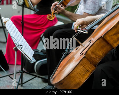 Groupe de musicien violoncelliste exécuter la musique dans la rue, Close up man playing violin Banque D'Images