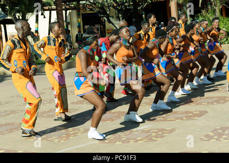 Lignes d'hommes et de femmes artistes de rue en costume traditionnel à l'acte culturel chansons zoulou, Durban, Afrique du Sud Banque D'Images