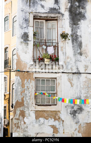 Appartement en pierre de la façade de l'immeuble, avec buanderie pour sécher suspendue depuis le balcon. La moisissure. Sur un vieux bâtiment blanchi à la chaux Banque D'Images