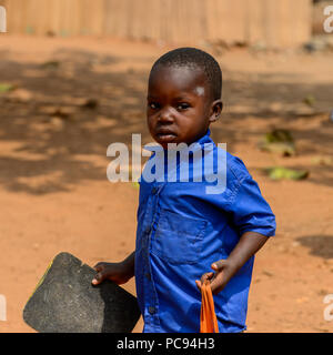 PIRA, BÉNIN - 12 jan 2017 : garçon sérieux béninois non identifiés, en uniforme d'horizons de l'école. Bénin enfants souffrent de la pauvreté en raison de la mauvais eco Banque D'Images