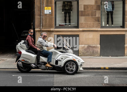 Couple riding un tricycle Can-Am Spyder 159 dans South Frederick Street, le fait de ne pas porter de casque. George Square en arrière-plan. Glasgow, Ecosse, Banque D'Images