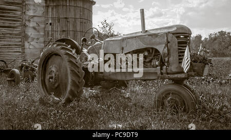 Un vieux millésime tracteur rouillé par la grange à Hopkinton, New Hampshire. Banque D'Images