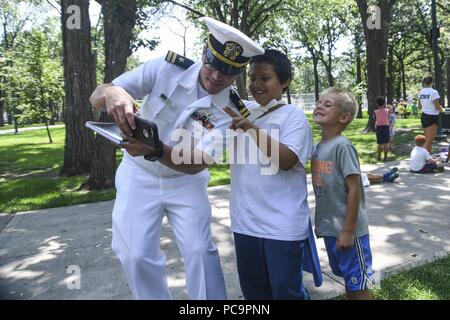 180724-N-VH385-0167 FARGO, N.D. (24 juillet 2018) - Le Lieutenant Mack Jamieson, originaire de Fulton, au Mississippi affectés à l'Office de la marine de l'approche communautaire, prend un avec les enfants de l'selfies le YMCA et les Clubs garçons et filles à Island Park à Fargo, N.D. durant la Semaine de la Marine Métro Fargo-Moorhead, 24 juillet 2018. Le Bureau de la marine de l'approche communautaire utilise le programme de la Semaine de la Marine d'apporter de l'équipement, marins et affiche à environ 14 villes américaines chaque année pour une semaine de calendrier des missions de sensibilisation conçu pour les Américains à l'expérience de première main comment l'US Navy est la Marine la nation née Banque D'Images