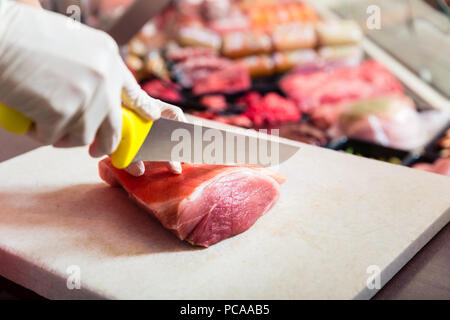 Femme dans une boucherie vendant de la viande filet Banque D'Images