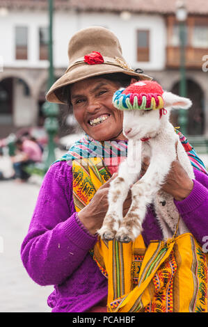 21 avril 2014 - Cusco, Pérou. Groupe de femmes indigènes qui posent avec les jeunes lamas. Portant des vêtements traditionnels colorés, des textiles et des chapeaux. Banque D'Images