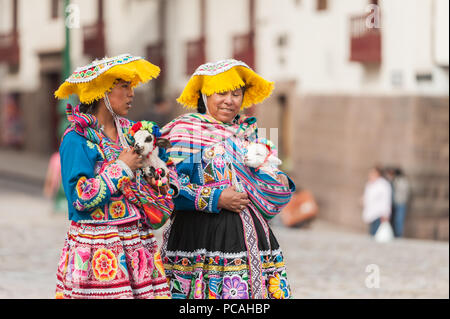21 avril 2014 - Cusco, Pérou. Groupe de femmes indigènes qui posent avec les jeunes lamas. Portant des vêtements traditionnels colorés, des textiles et des chapeaux. Banque D'Images