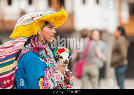 21 avril 2014 - Cusco, Pérou. Groupe de femmes indigènes qui posent avec les jeunes lamas. Portant des vêtements traditionnels colorés, des textiles et des chapeaux. Banque D'Images