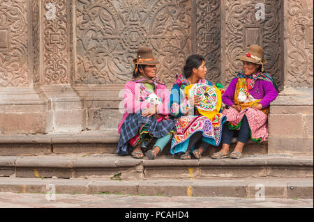21 avril 2014 - Cusco, Pérou. Groupe de femmes indigènes qui posent avec les jeunes lamas. Portant des vêtements traditionnels colorés, des textiles. Banque D'Images