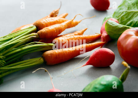 Carottes fraîches bunch avec ensemble de légumes sur fond gris Banque D'Images