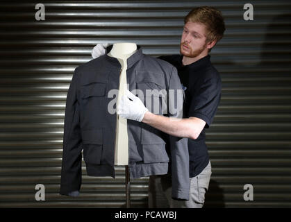 Soutenir l'employé du magasin James Chapamn ajuste Han Solo's jacket, porté par Harrison Ford dans Star Wars : The Empire Strikes Back (estimation &pound;500 000 - &pound;), il faut remarquer sur l'affichage à la prop Store siège social près de Rickmansworth avant la vente aux enchères des souvenirs de divertissement le 20 septembre. Banque D'Images