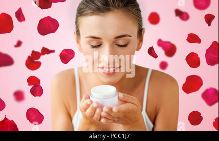 Close up of woman smelling crème sur des pétales de rose Banque D'Images