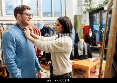 Couple choisissant des vêtements au magasin de vêtements vintage Banque D'Images