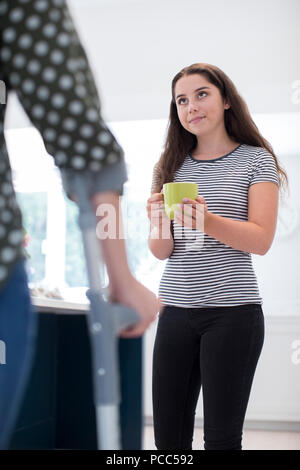 Fille adolescente faisant boire pour parent invalide Banque D'Images