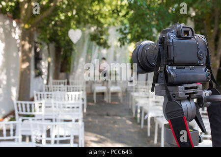 Appareil photo reflex numérique monté sur trépied prêt pour l'enregistrement de mariage. Site arrangement de mariage Banque D'Images