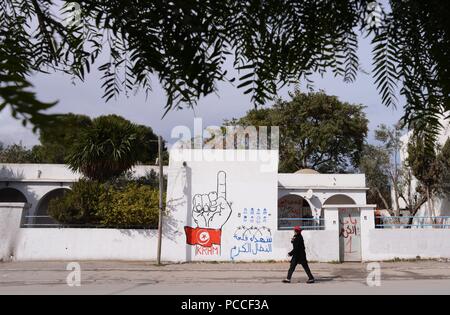 12 février 2013 - Tunis, Tunisie : Peinture murale graffiti à l'extérieur de l'édifice abritant la Ligue pour la protection de la révolution (LPR) dans le quartier Kram de Tunis. Le LPR sont la nébuleuse des groupes de miliciens qui sont pensés pour être le bras armé du parti islamiste Ennahda. Le soi-disant "gardiens" volutionnary ont été blâmés pour une vague d'attaques contre les politiciens séculiers qui a culminé avec l'assassinat de la figure de l'opposition Chokri Belaid. Jeunes hommes membres du comité local de la Ligue de Protection de la révolution dans le quartier du Kram a Tunis. *** FRANCE / PAS DE VENTES Banque D'Images