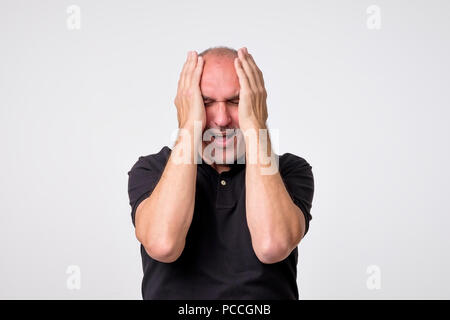 Desperate young man pleurer dans ses mains Banque D'Images