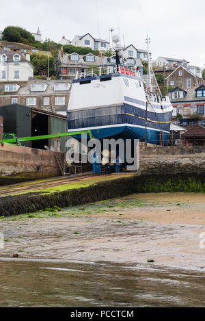 Bateau de pêche établies sur la cale en cours de réparation à C. Toms & Son chantier à Polruan, Cornwall, England, UK Banque D'Images