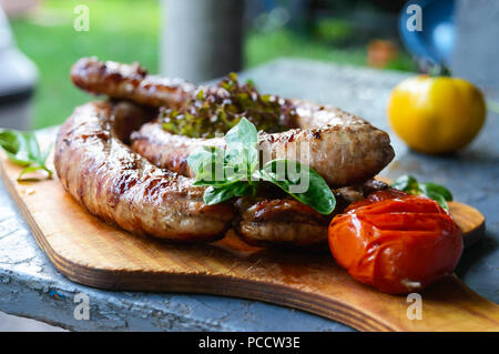 Saucisses de porc frit dans le feu. Banque D'Images