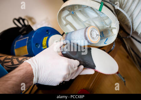 Le processus de fabrication des semelles orthopédiques pour les personnes atteintes de maladies de la jambe, les pieds plats. Close-up de la main d'un homme d'un employé demande instamment une o Banque D'Images