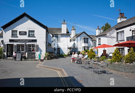 Gens touristes visiteurs assis à l'extérieur du village pub en été Hawkshead Cumbria Angleterre Royaume-Uni Grande-Bretagne Banque D'Images