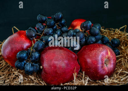Des pommes mûres rouges et les raisins noirs Banque D'Images