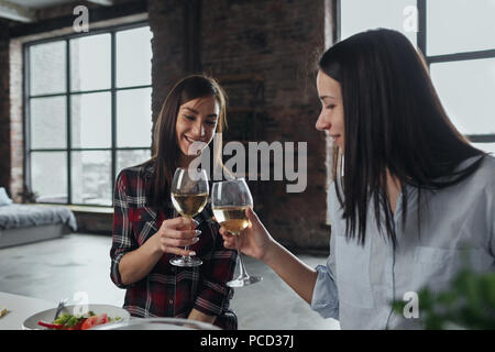 Deux amis joyeux dîner et boire du vin à la maison Banque D'Images