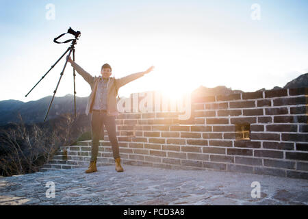 Happy young Chinese man photographing on the Great Wall Banque D'Images