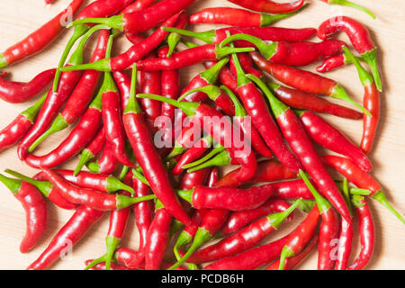 Ripe red chili peppers on wooden table Banque D'Images