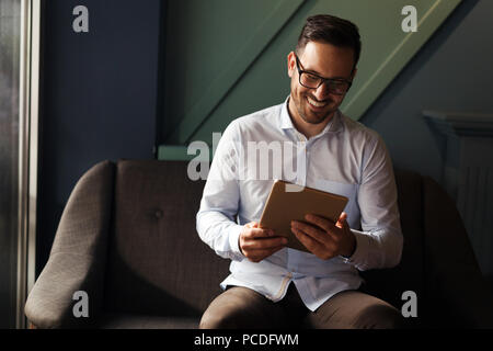 Businessman wearing glasses holding tablet Banque D'Images