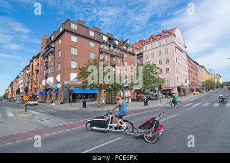 STOCKHOLM, Suède - 11 juillet 2018 : cycliste avec chariots enfant traverse Sankt Eriksplan à Vasastan le 11 juillet 2018 à Stockholm, en Suède. Banque D'Images