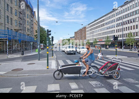 STOCKHOLM, Suède - 11 juillet 2018 : cycliste avec chariots enfant Fridhemsplan traverse le 11 juillet 2018 à Stockholm, en Suède. Banque D'Images