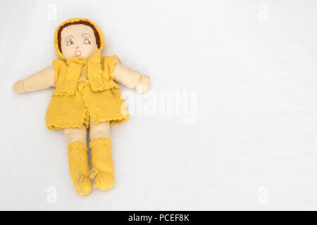 Tricot Main Antique Doll jaune sur fond blanc Banque D'Images