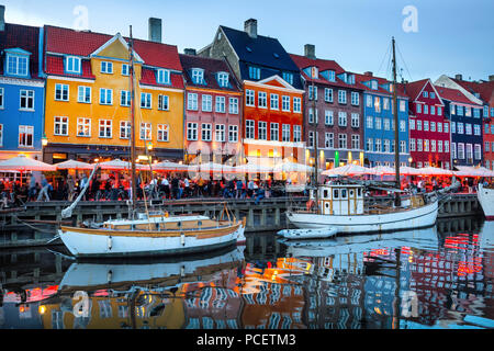 Voiliers amarrés par Nyhavn, promenade éclairés en soirée, vieille ville de Copenhague, Danemark cityscape Banque D'Images