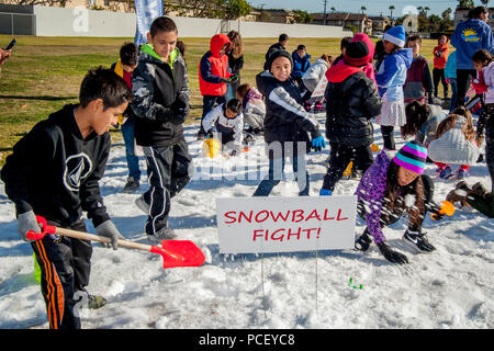 Les écoliers multiraciale qui n'ont jamais vu jouer sur la neige artificielle de 10 tonnes d'afficher sur leur terrain d'école sur une chaude journée d'hiver de Costa Mesa, CA, (Photo de Spencer Grant) Banque D'Images