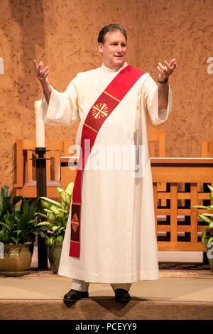 Un shashed-robed et du diacre procède à une Liturgie de la Parole avec Rite de Communion à l'autel d'une Laguna Niguel, CA, l'église catholique. Banque D'Images