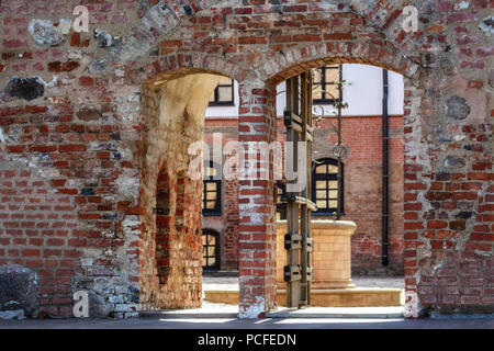 Une double porte avec un arc dans un vieux mur de brique menant à la cour intérieure de la forteresse. Banque D'Images