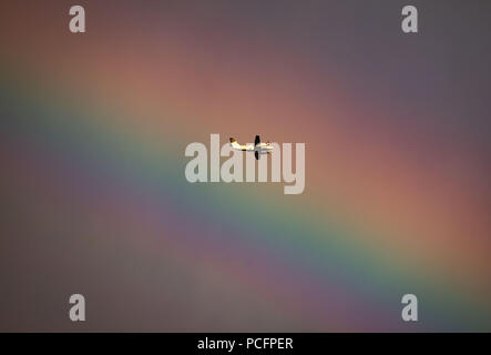 Frankfurt am Main, Allemagne. 06Th Aug 2018. Un avion à hélice vole dans un arc-en-ciel qui s'était formé sur la ville dans la soirée. Crédit : Frank Rumpenhorst/dpa/Alamy Live News Banque D'Images