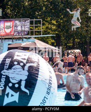 02 août 2018, Wacken, Allemagne : Les Visiteurs du Wacken Open Air festival se rafraîchir dans la piscine. Une femme passe de la commission plongée dans l'eau. Selon les organisateurs, le plus grand festival de heavy metal commence avec 75 000 visiteurs. Photo : Axel Heimken/dpa Banque D'Images