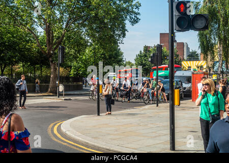 Les cyclistes l'attente aux feux de circulation en face de taxis, carte et red double decker bus dans Baylis Road, Southwark, London, UK. Banque D'Images