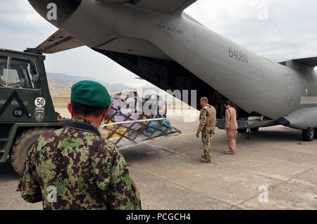 Kaboul, Afghanistan -- membres allemands de la Force internationale d'assistance et d'aviateurs de la 438th Air Expeditionary Advisory Group, décharger un avion de transport C-27 Spartan chargé avec l'aide humanitaire à l'aéroport international de Faizabad, Afghanistan. L'aide doit être déposée dans la région sud du Badakhshan, le 23 juin 2010. (US Navy Banque D'Images